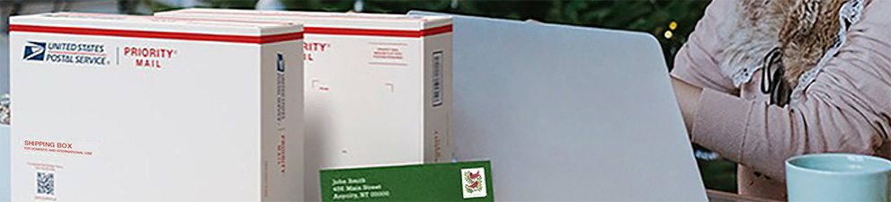 A woman preparing to ship holiday gifts with a Priority Mail Express box and a Priority Mail box.