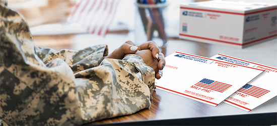 Military service member holding a special Priority Mail APO/FPO Large Flat Rate Box.